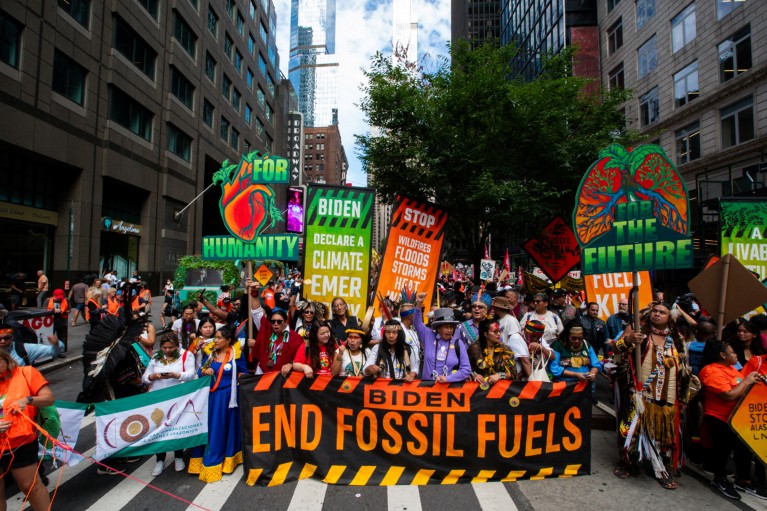 Activists holding signs march during Climate Week in New York