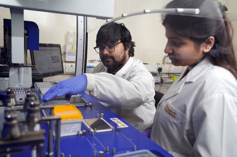 Two young researchers at icddr,b Genome Centre are seen in the lab processing microbiome samples
