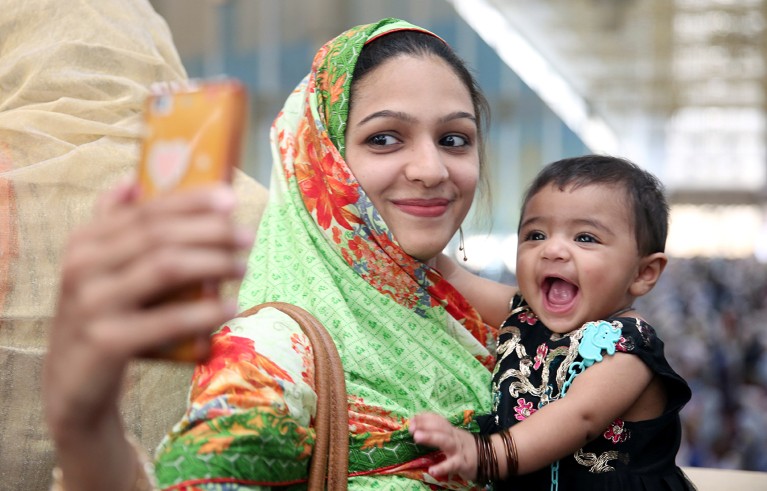 A mother with a child takes a selfie after attending Friday prayers at the Faisal mosque during the fasting month of Ramadan in Islamabad, Pakistan.