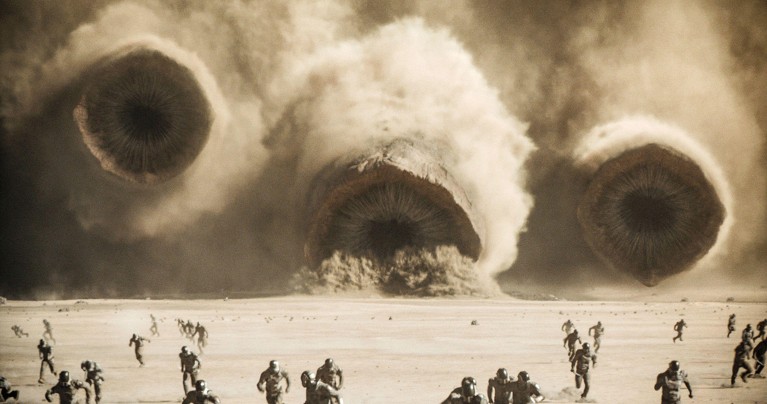 Three giant worms with long teeth in circular mouths emerge from a sandstorm; people are running away.