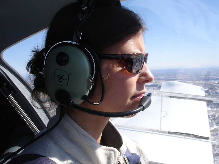 Claudia de Rham in the cockpit of a plane.