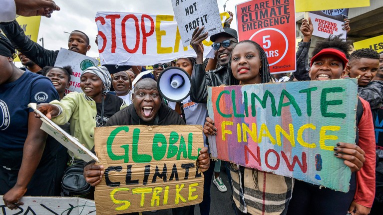 Climate activists hold placards and chant slogans as they take part in a march in Nairobi on September 4, 2023.