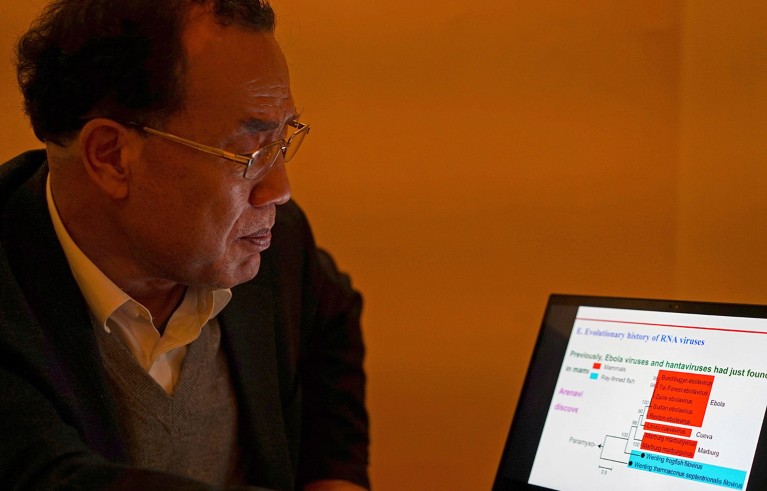 Zhang Yongzhen, the first scientist to publish a sequence of the COVID-19 virus, looks at a presentation on his laptop in a coffeeshop in Shanghai, China on Dec. 13, 2020.