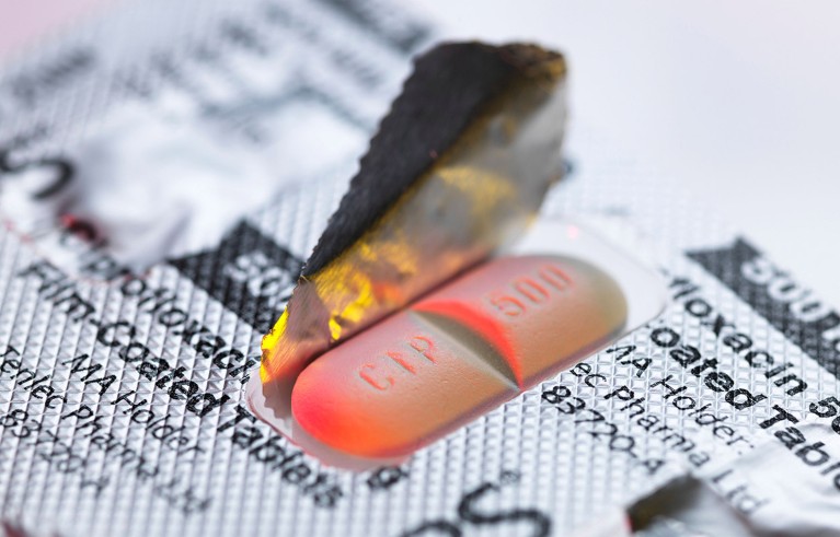 A single Ciprofloxacin tablet in its partially opened packaging.