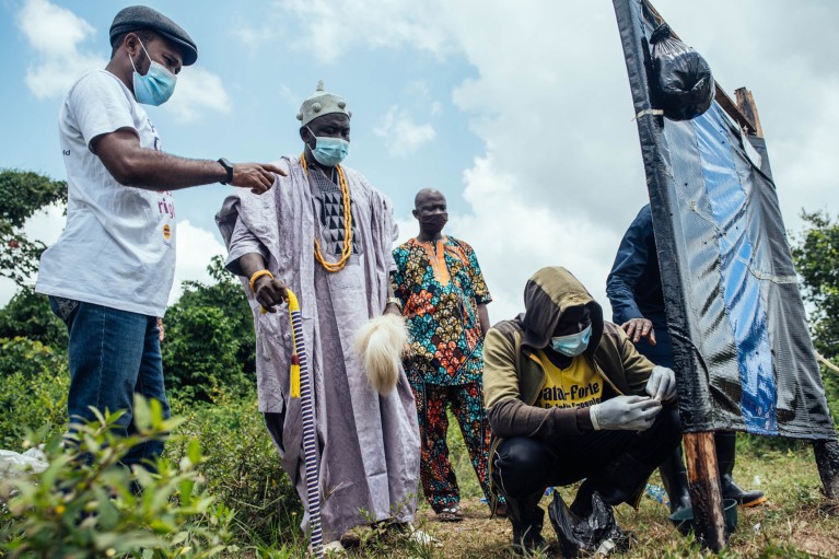 Sightsavers researchers work with community members in Nigeria on an Esperanza window trap to trap blackfly