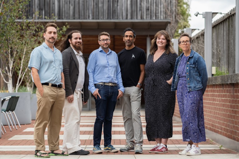A group portrait of six of ARIA's programme directors stood in a courtyard outside of The British Library
