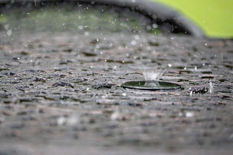 Close-up of rain falling down and raindrops splashing.
