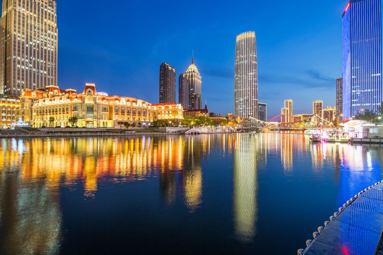The lights of buildings in Tianjin, China are seen reflected in water at night