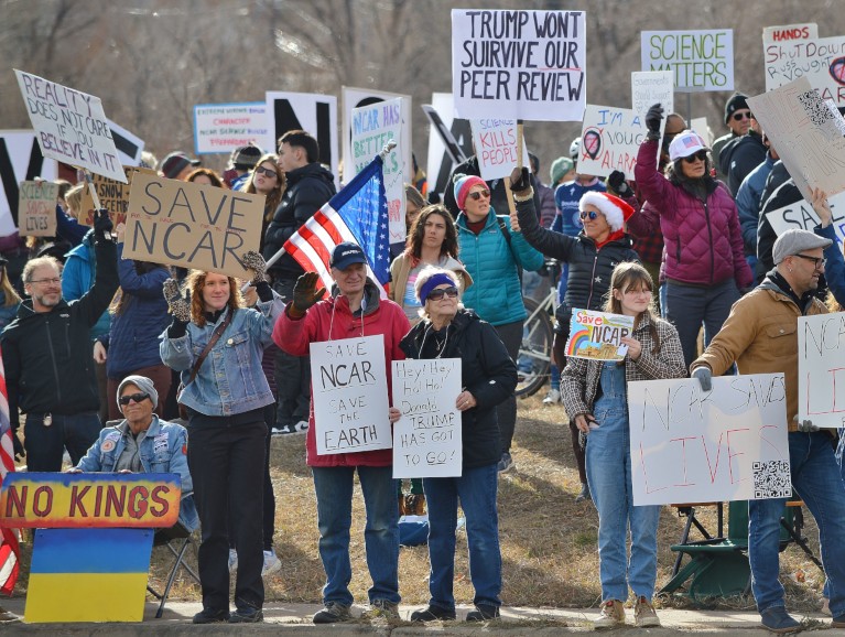 Demonstrators holding placards and banners with in support of the NCAR.