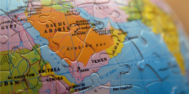 Jigsaw puzzle pieces forming a map of the Middle East, with Saudi Arabia the focal point