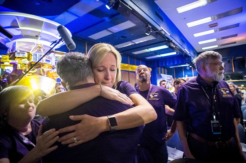 Scientists and Cassini team members hug