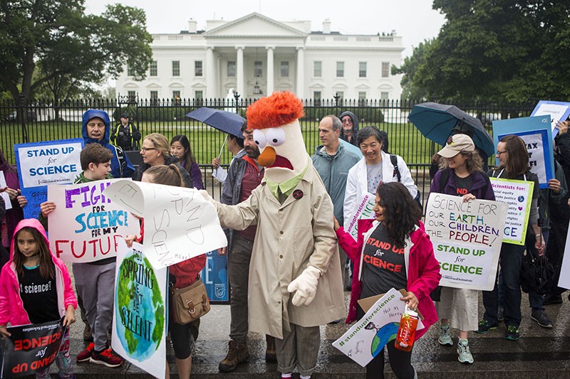 Members of the Union for Concerned Scientists pose for photographs with Muppet character Beaker in front of The White House