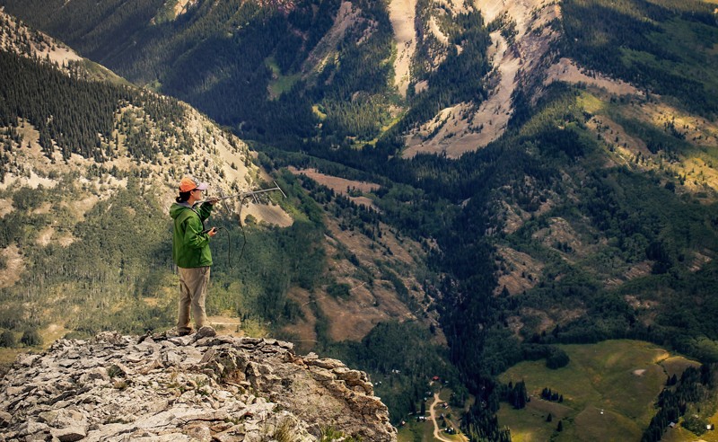 Woman holding antenna in mountains