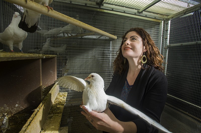 Rebecca Calisi RodrÃ­guez holds a rock dove