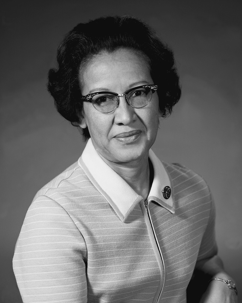 Black and white photo of a woman in 1950s dress.