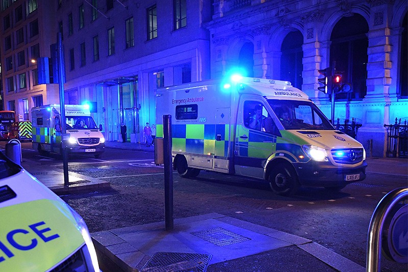 Ambulances head north from London Bridge at night.