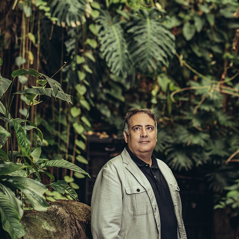 Alex Duhgan in front of lush tree growth