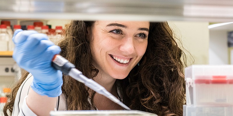 Alanna Gannon holds a pipette in a lab