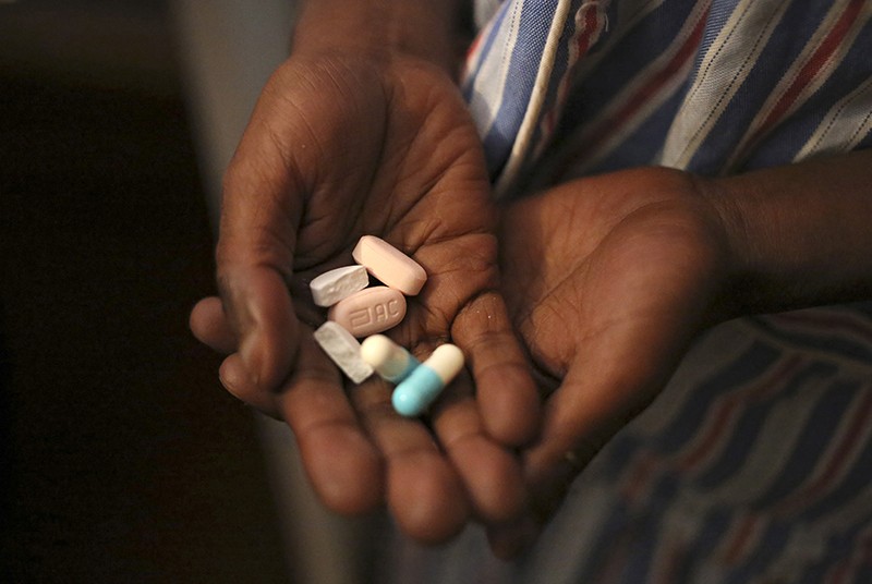 Nine-year-old Tumelo shows off antiretroviral (ARV) pills before taking his medication at Nkosi's Haven, south of Johannesburg