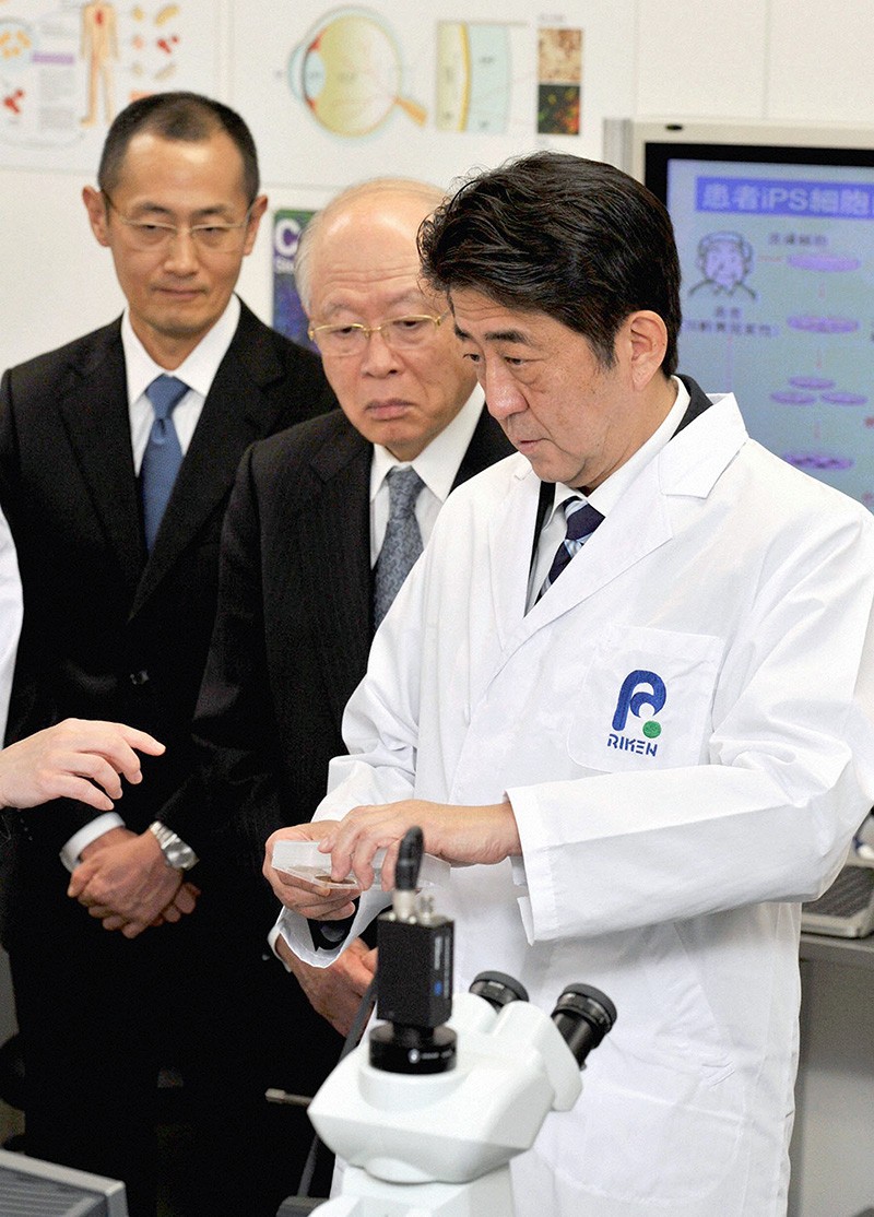 Japanese Prime Minister Shinzo Abe (right) and Shinya Yamanaka (left) at a Riken lab in Kobe, Japan