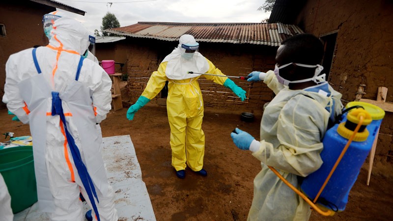 Kavota Mugisha Robert, a healthcare worker, who volunteered in the Ebola response, decontaminates his colleague.